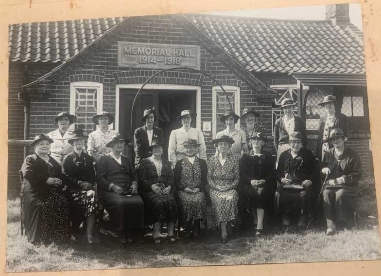 An early group photo in front of the hall